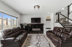 The living area features a dark marble-style fireplace, recessed lighting, and a large window - 