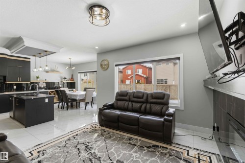 This open-concept living area features light-toned walls, recessed lighting, and a contemporary ceiling light fixture - 1520 151 Avenue, Edmonton, AB - Indoor