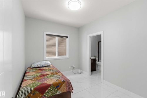 Bright room featuring a window with blinds, a ceiling light fixture, and white tile flooring - 1520 151 Avenue, Edmonton, AB - Indoor Photo Showing Bedroom