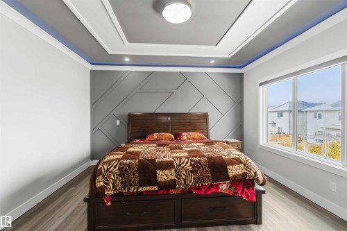 This sleeping area features a decorative ceiling with recessed lighting and a contemporary accent wall - 1520 151 Avenue, Edmonton, AB - Indoor Photo Showing Bedroom