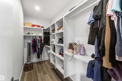 The property features a walk-in closet with built-in white shelving and hanging rods - 