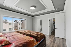 This room features a tray ceiling with a central light fixture, a large window, and durable flooring - 
