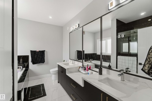Modern bathroom featuring a dual vanity with rectangular sinks, black cabinetry, and light-colored countertops - 1520 151 Avenue, Edmonton, AB - Indoor Photo Showing Bathroom