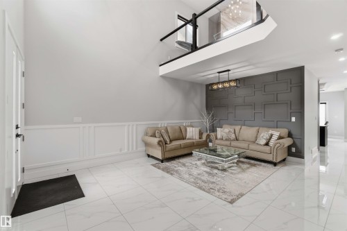 This living area features a high ceiling, white tile flooring, and wainscoting - 1520 151 Avenue, Edmonton, AB - Indoor