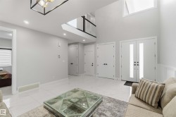 The property entrance features a double door with vertical glass inserts, high ceilings, and white tile flooring - 