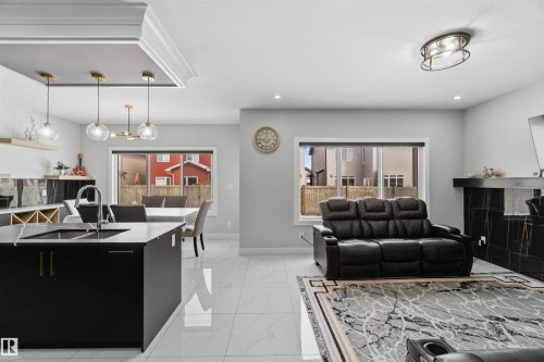 Open concept living area featuring light-toned tile flooring, recessed lighting, and large windows providing natural light - 1520 151 Avenue, Edmonton, AB - Indoor Photo Showing Other Room