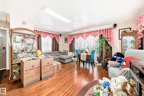 This living area features hardwood floors and windows with drapes, providing natural light - 16305 107A Ave, Edmonton, AB - Indoor