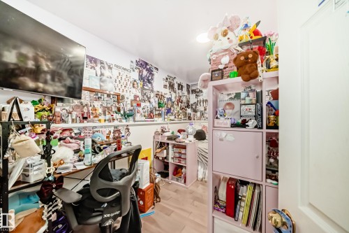 This room features light-toned flooring, a wall-mounted television, and a white ceiling with recessed lighting - 16305 107A Ave, Edmonton, AB - Indoor