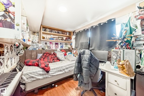 Room featuring hardwood floors, a window with dark curtains, and a ceiling light fixture - 16305 107A Ave, Edmonton, AB - Indoor