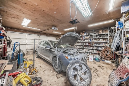 The property features a garage with a wooden ceiling and fluorescent lighting - 16305 107A Ave, Edmonton, AB - Indoor Photo Showing Garage