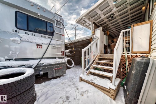 Covered exterior entrance with wooden stairs and white railings - 16305 107A Ave, Edmonton, AB -  Photo Showing Other Room