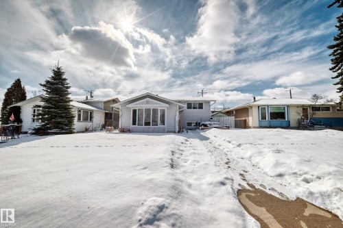 The property features a front yard with snow cover and a visible path, a bay window, and exterior siding - 16305 107A Ave, Edmonton, AB - Outdoor
