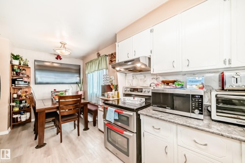 The kitchen features white cabinetry, stainless steel appliances, and a light-colored countertop - 16305 107A Ave, Edmonton, AB - Indoor Photo Showing Kitchen