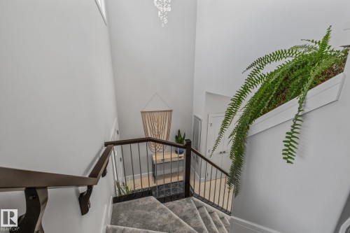 Staircase featuring dark wood handrails, black metal balusters, and carpeted stairs - 3864 Robins Crescent, Edmonton, AB - Indoor Photo Showing Other Room