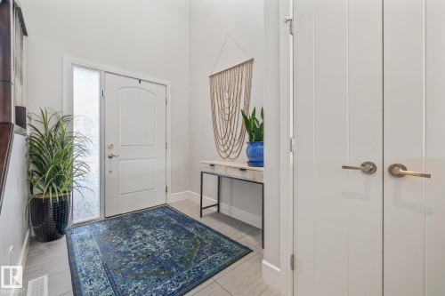 Inviting entryway with a white front door featuring a decorative arch and a frosted glass sidelight - 3864 Robins Crescent, Edmonton, AB - Indoor Photo Showing Other Room