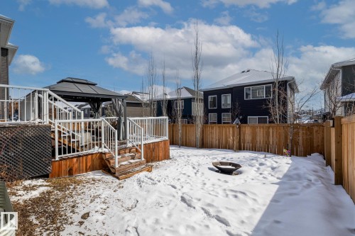 The property features a wooden deck with white railings and an outdoor gazebo, overlooking a fenced yard - 3864 Robins Crescent, Edmonton, AB - Outdoor