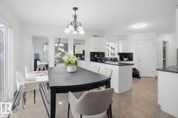 The property features a bright kitchen and dining area with white walls and a tiled floor - 