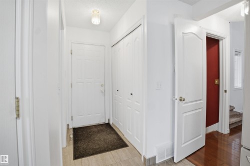 Entryway featuring light-colored tile flooring, a white door, and a closet with bifold doors - 4619 202 Street, Edmonton, AB - Indoor Photo Showing Other Room