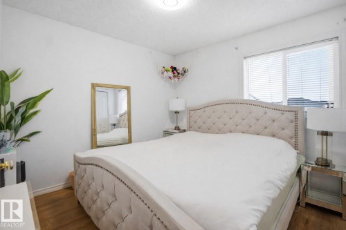 The bedroom features hardwood floors, white walls, and a window with blinds - 4619 202 Street, Edmonton, AB - Indoor Photo Showing Bedroom