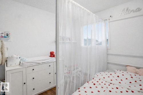 This room features white walls, a window with blinds, and white sheer curtains - 4619 202 Street, Edmonton, AB - Indoor Photo Showing Bedroom