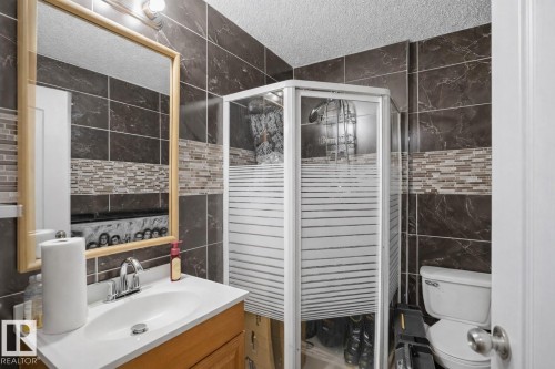 Bathroom featuring a vanity with an integrated sink, a framed mirror, and a corner shower enclosure - 4619 202 Street, Edmonton, AB - Indoor Photo Showing Bathroom