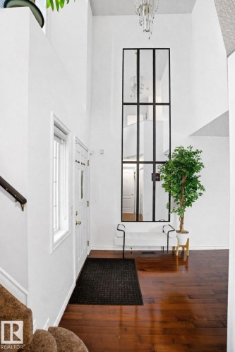 The property features high ceilings, hardwood flooring, and a decorative chandelier - 4619 202 Street, Edmonton, AB - Indoor Photo Showing Other Room