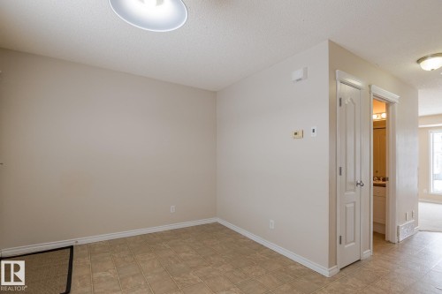 This area features neutral tone walls and tile flooring, with a ceiling light fixture - 58 Birchmont Drive, Leduc, AB - Indoor Photo Showing Other Room