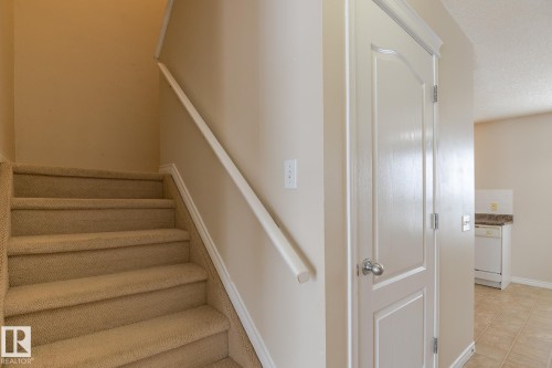 Carpeted staircase with a white handrail - 58 Birchmont Drive, Leduc, AB - Indoor Photo Showing Other Room