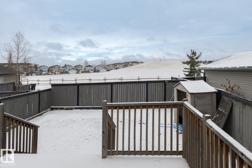 The property features a fenced yard, a wooden deck with railings, and a storage shed - 58 Birchmont Drive, Leduc, AB - Outdoor With Deck Patio Veranda