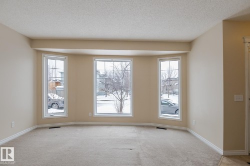 The property features a bay window with three large panes, providing ample natural light - 58 Birchmont Drive, Leduc, AB - Indoor Photo Showing Other Room