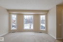 The property features a bay window with three large panes, providing ample natural light - 58 Birchmont Drive, Leduc, AB  - Indoor Photo Showing Other Room 