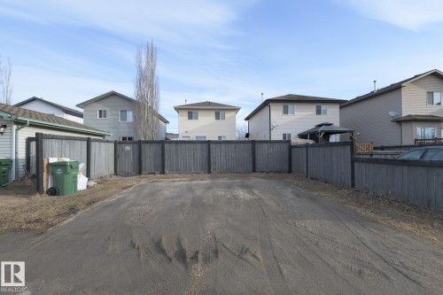 The property features a fenced yard with a gravel surface - 58 Birchmont Drive, Leduc, AB - Outdoor