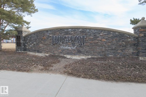The property is part of the Bridgeport Boulevard community, indicated by the stone entrance sign featuring the community name - 58 Birchmont Drive, Leduc, AB - Outdoor With View