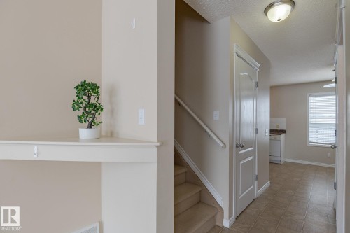 The property features a staircase with carpeted treads and a handrail - 58 Birchmont Drive, Leduc, AB - Indoor Photo Showing Other Room