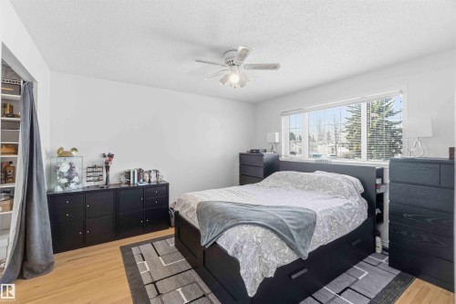 The property features light wood flooring, a window with blinds, and a ceiling fan - 4023 86 Street Nw, Edmonton, AB - Indoor Photo Showing Bedroom