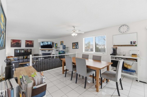 The dining area features white tiled floors, a window with blinds, and a dining table with six chairs - 4023 86 Street Nw, Edmonton, AB - Indoor Photo Showing Dining Room