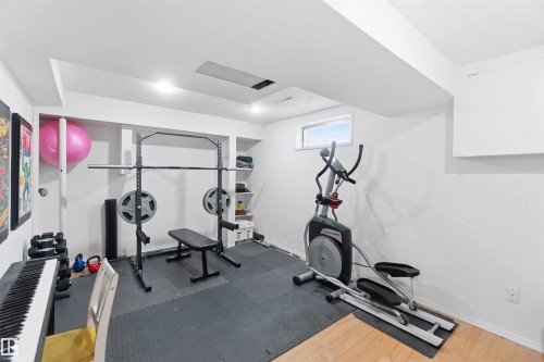 The property features a dedicated fitness area with recessed lighting, a window providing natural light, and a combination of soft and hard flooring surfaces - 4023 86 Street Nw, Edmonton, AB - Indoor Photo Showing Gym Room