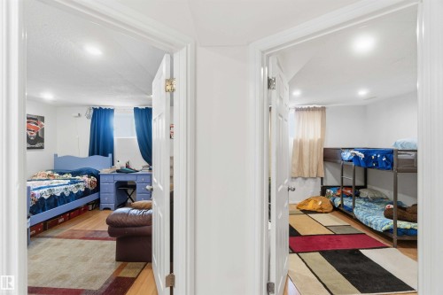 Interior view featuring two rooms with hardwood flooring, recessed lighting, and white walls - 4023 86 Street Nw, Edmonton, AB - Indoor