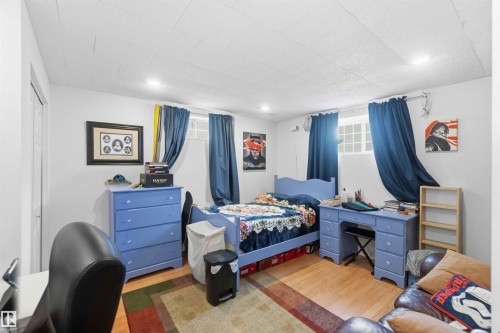 This room features light wood flooring, recessed lighting, and two windows - 4023 86 Street Nw, Edmonton, AB - Indoor Photo Showing Bedroom