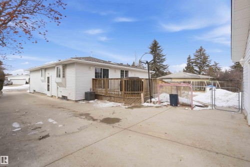 The property features a white exterior with a deck and a concrete patio - 4023 86 Street Nw, Edmonton, AB - Outdoor