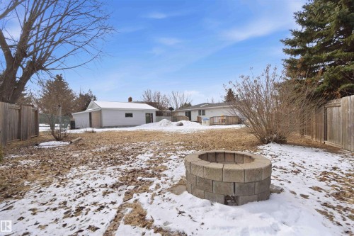 The property features an extensive yard with a fire pit constructed from concrete blocks - 4023 86 Street Nw, Edmonton, AB - Outdoor