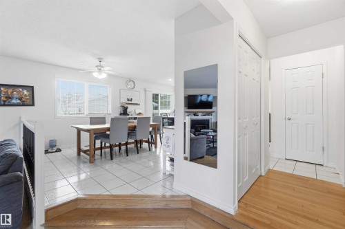 This property features a dining area with tile flooring and a ceiling fan, illuminated by natural light from large windows - 4023 86 Street Nw, Edmonton, AB - Indoor