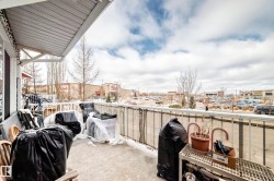 The property features an exterior balcony with a railing and an awning, offering views of the surrounding area - 