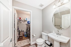 The property features a dedicated laundry area with a washer and dryer, located conveniently near a bathroom with a pedestal sink, a circular mirror, and a toilet - 