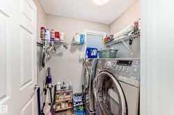 Well-appointed laundry area featuring a washer and dryer, wire shelving for storage, and a light-colored door - 