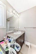 Bathroom vanity with a white basin and a speckled countertop - 