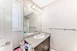 Bathroom featuring a vanity with a light-colored countertop, an integrated sink, and a large mirror - 
