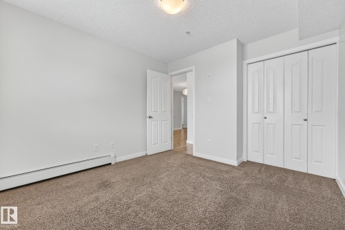 This room features neutral-toned carpeting, white walls, and a ceiling light fixture - 301 1070 Mcconachie Boulevard, Edmonton, AB - Indoor Photo Showing Other Room