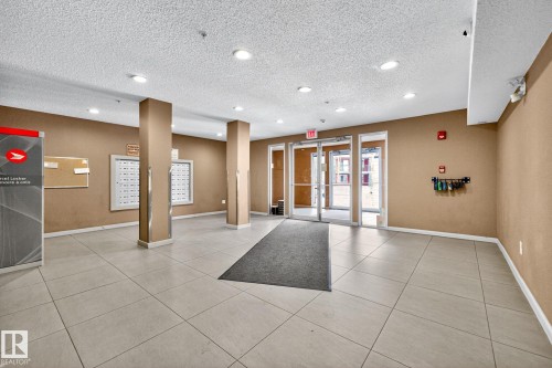 The property features an entrance area with light-colored floor tiles, recessed lighting, and a neutral wall color - 301 1070 Mcconachie Boulevard, Edmonton, AB - Indoor Photo Showing Other Room