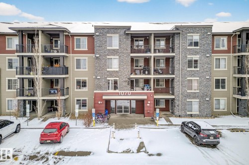 The property features a multi-story exterior with a combination of neutral-toned siding and stone cladding - 301 1070 Mcconachie Boulevard, Edmonton, AB - Outdoor With Balcony With Facade
